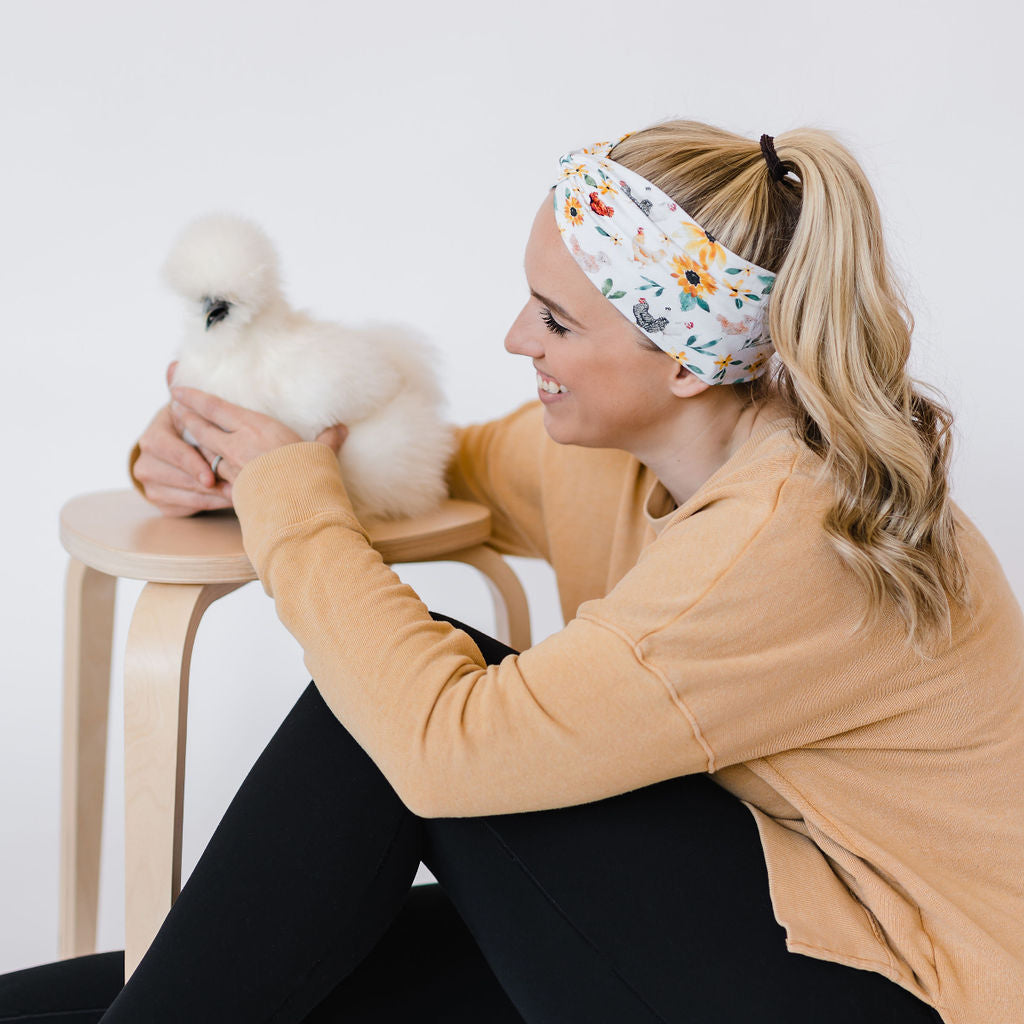 Adult women's white headband with yellow sunflowers with leaves and different breeds of chickens with brown, black, white, and multi-colored feathers