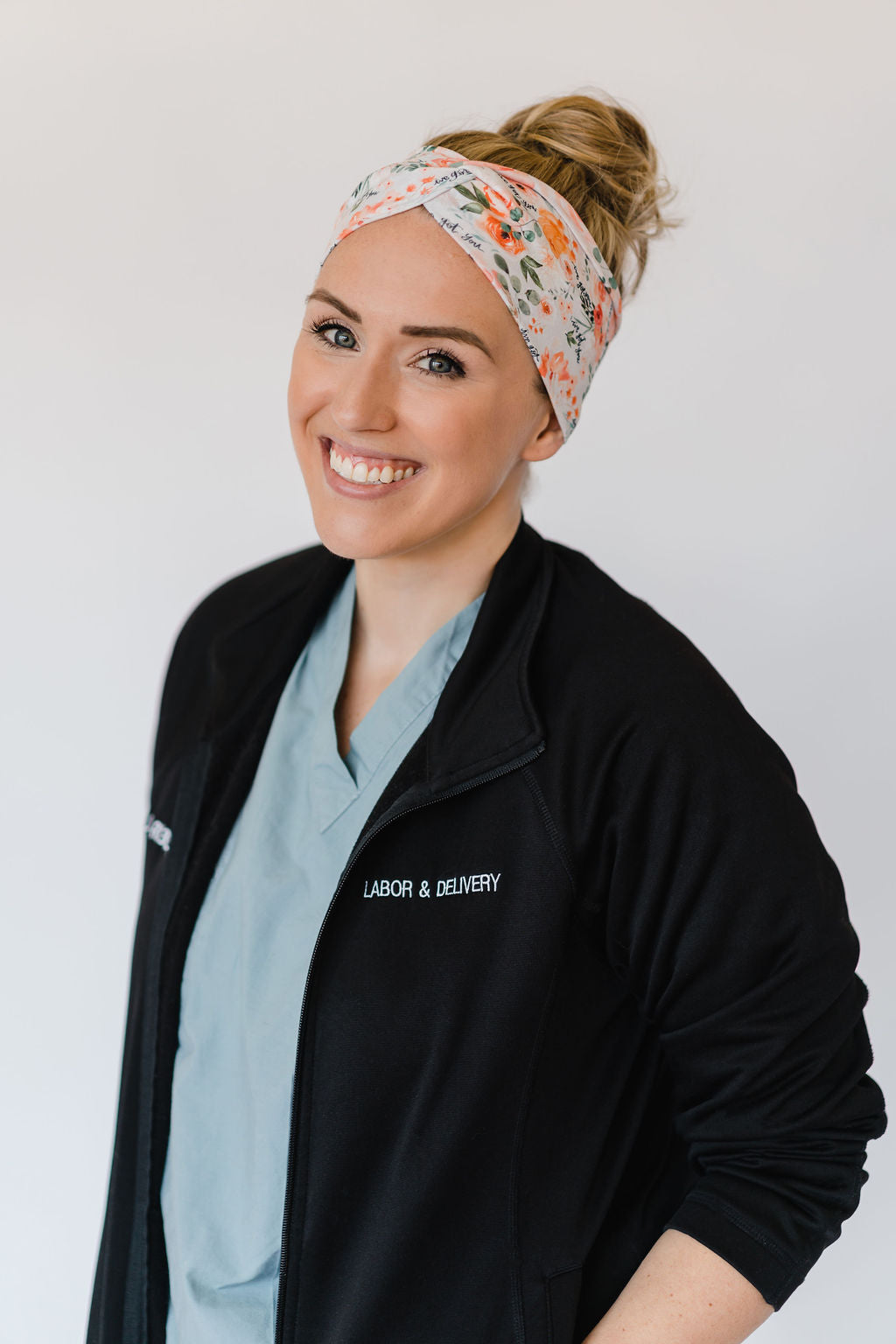 Adult women's ivory headband with watercolor coral, orange, peach and ivory flowers and leaves with the cursive script "I've got you" hidden throughout the print