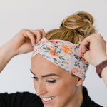 Adult women's ivory headband with watercolor coral, orange, peach and ivory flowers and leaves with the cursive script "I've got you" hidden throughout the print