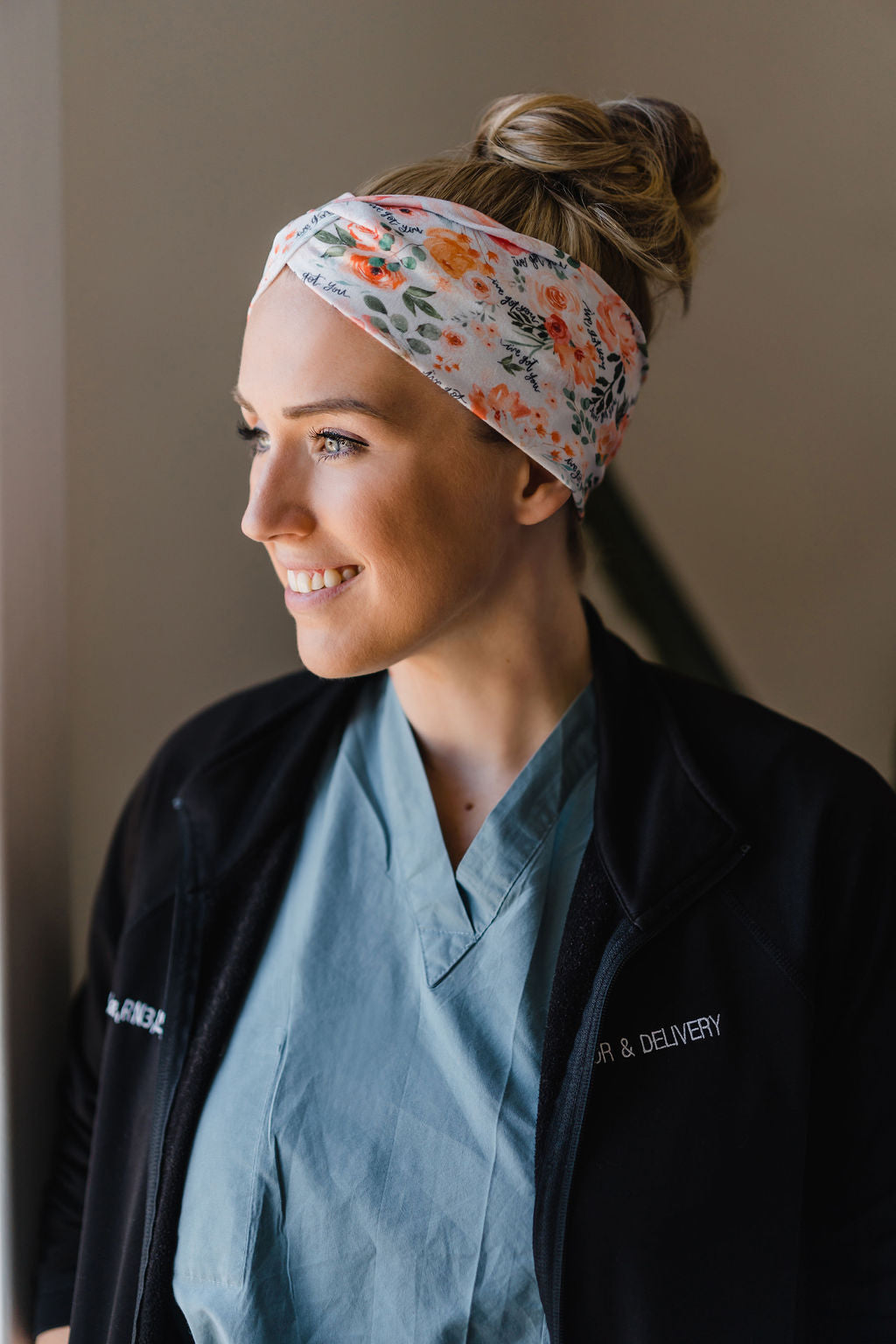 Adult women's ivory headband with watercolor coral, orange, peach and ivory flowers and leaves with the cursive script "I've got you" hidden throughout the print