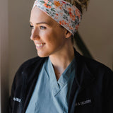 Adult women's ivory headband with watercolor coral, orange, peach and ivory flowers and leaves with the cursive script "I've got you" hidden throughout the print