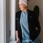 Adult women's ivory headband with watercolor coral, orange, peach and ivory flowers and leaves with the cursive script "I've got you" hidden throughout the print