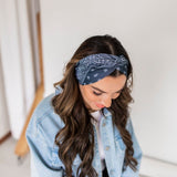 Adult women’s black headband with white paisley bandana print.