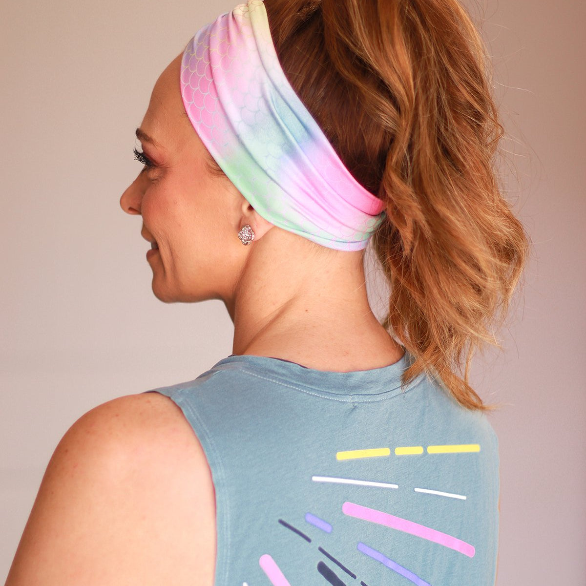 Adult women's tie dye headband with pink, mint, purple and yellow colors with allover mermaid scale print