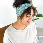 Adult women's light teal headband with allover black and white cartoon chicken print