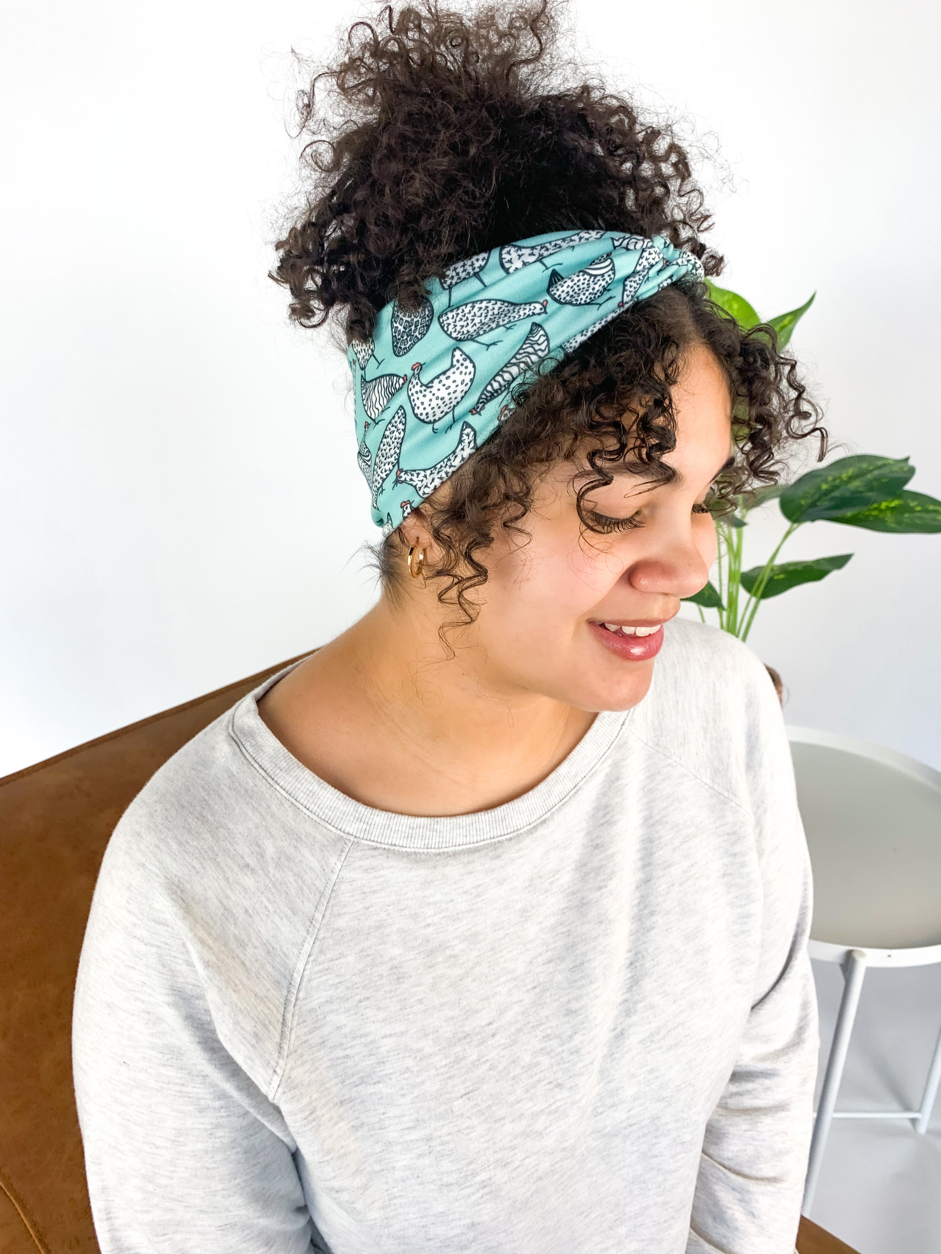 Adult women's light teal headband with allover black and white cartoon chicken print
