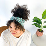 Adult women's light teal headband with allover black and white cartoon chicken print