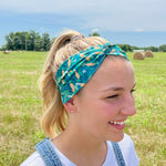 Adult women's dark green headband with yellow corn on the husk with different shades of green leaves