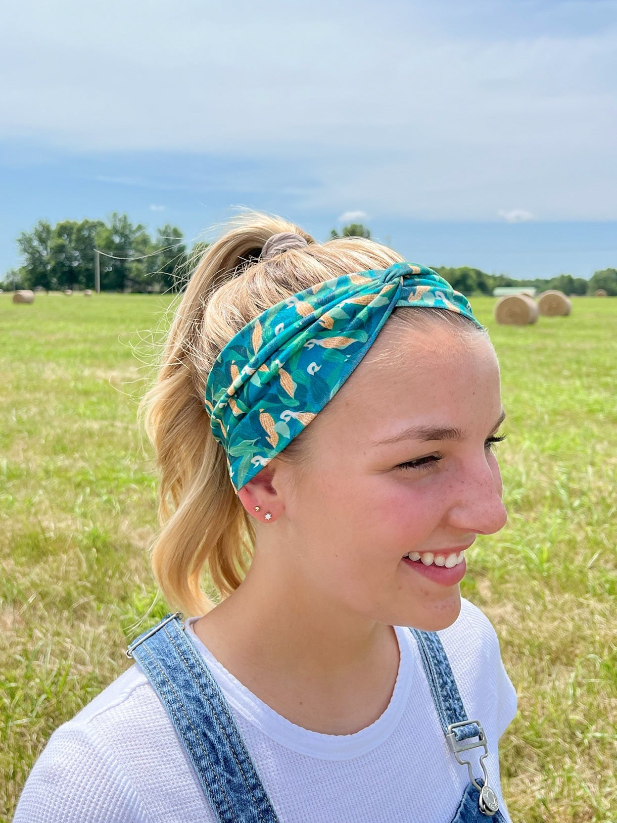 Adult women's dark green headband with yellow corn on the husk with different shades of green leaves