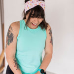 Adult women's white headband with orange, slate, tan, blush and plum pawprints, hearts and words they say "cat mom"