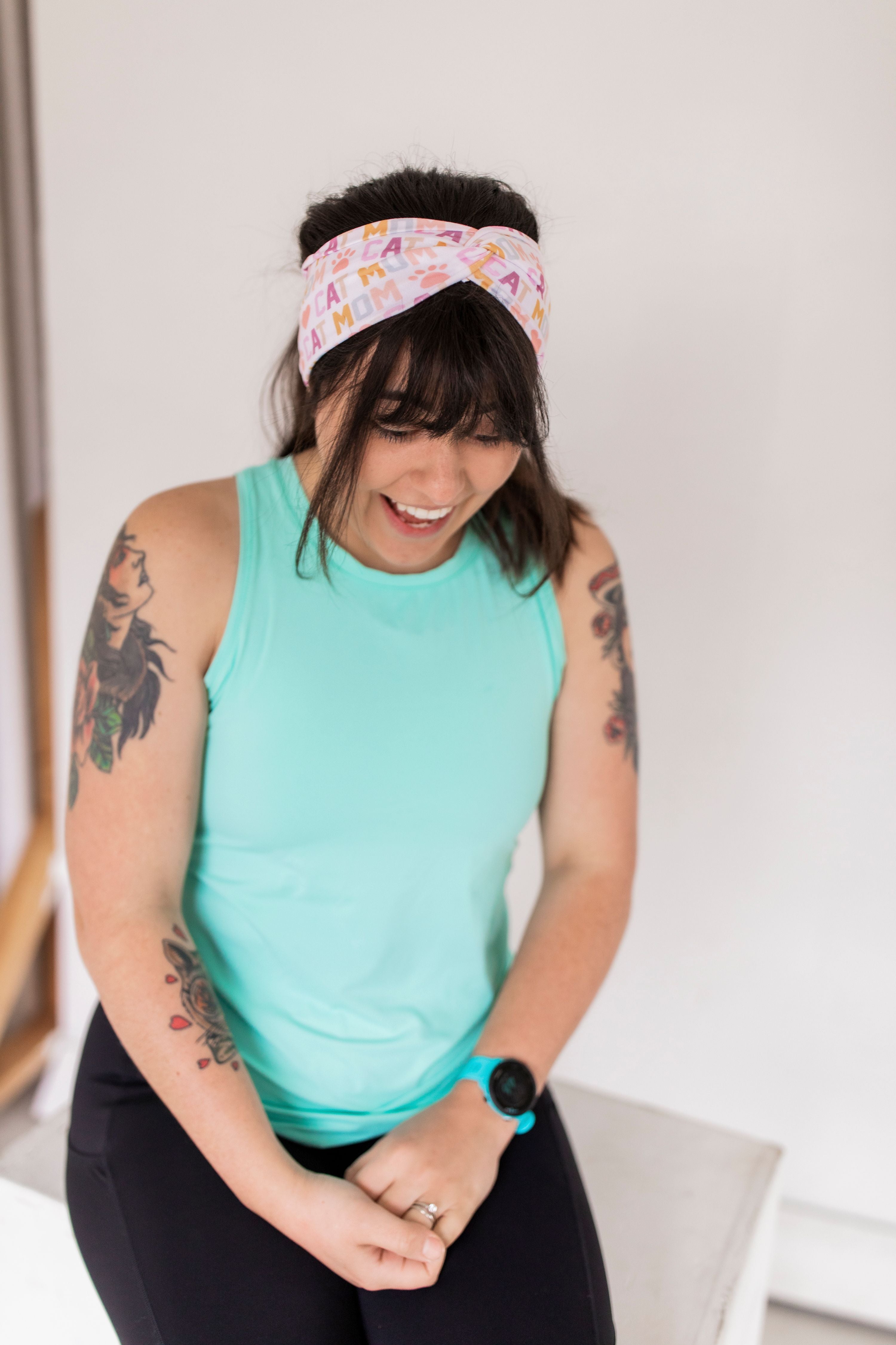 Adult women's white headband with orange, slate, tan, blush and plum pawprints, hearts and words they say "cat mom"