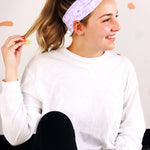 Adult women’s purple headband with medium white, dark and light purple floral allover pattern.