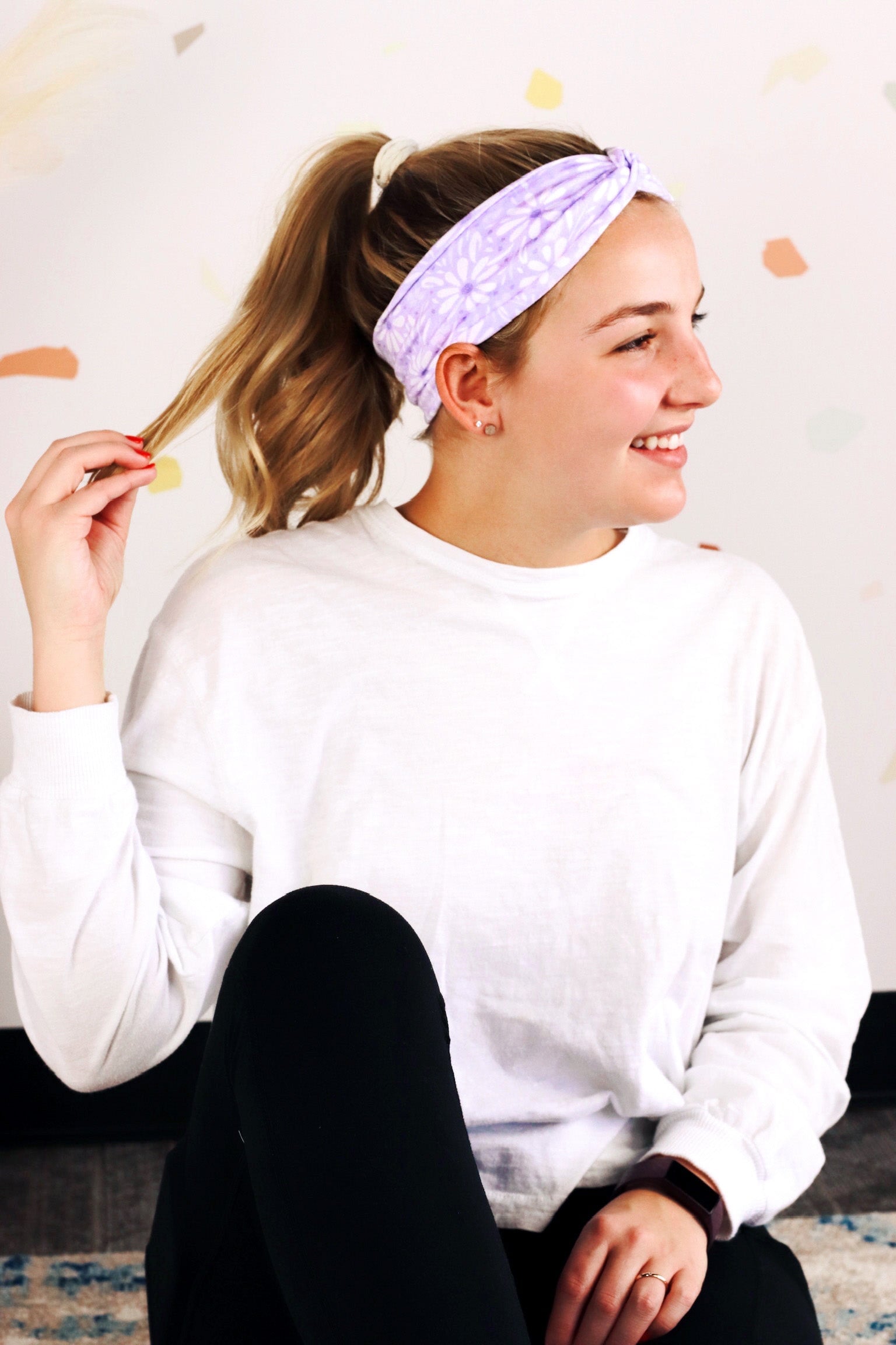 Adult women’s purple headband with medium white, dark and light purple floral allover pattern.