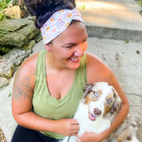 Adult women's white headband with orange, slate, tan, blush and plum pawprints, hearts and words they say "dog mom"