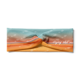 Adult women's gradient headband with yellow, orange and blue with allover white shoe prints, three yellow, orange and white horizontal lines and the white script saying "enjoy the miles"