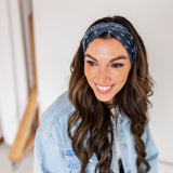 Adult women’s black headband with white paisley bandana print.