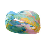Adult women’s headband with allover layered watercolor paint brushstroke print in varying oranges, pinks, yellows, blues, greens and whites.