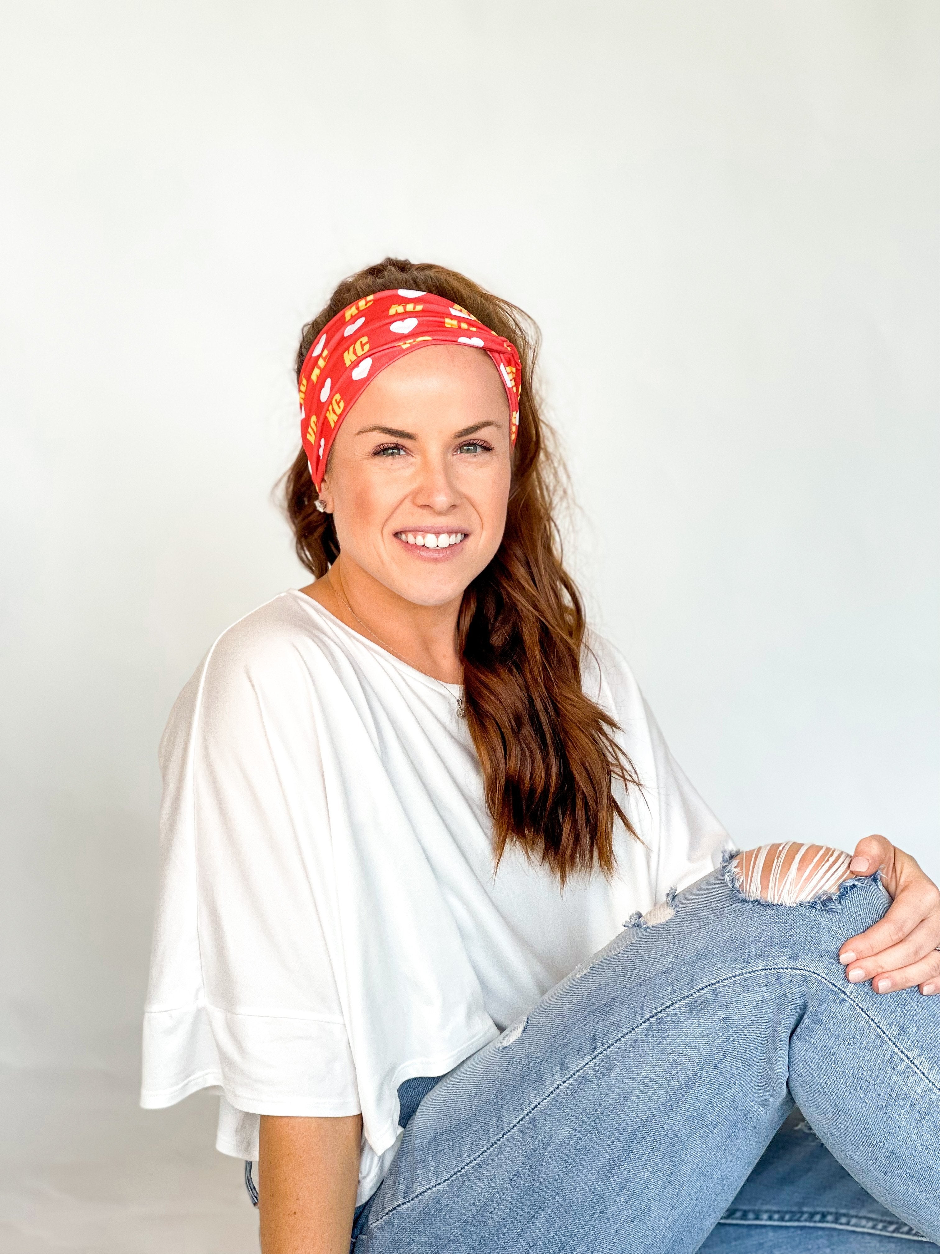 Adult women's red headband with white hearts and bright yellow "KC" pattern