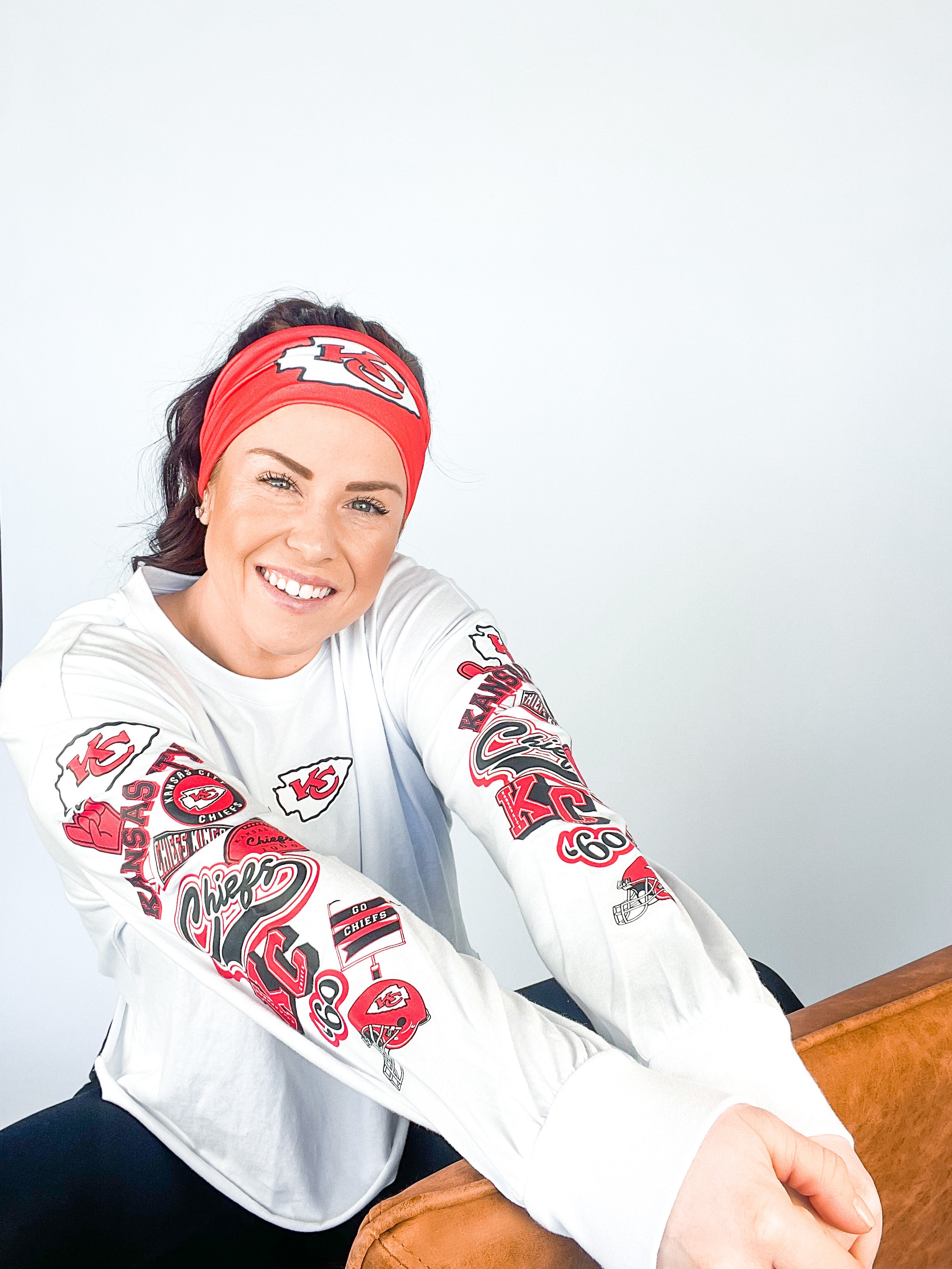 Adult women's red headband with one white arrowhead and red "KC" font in the center