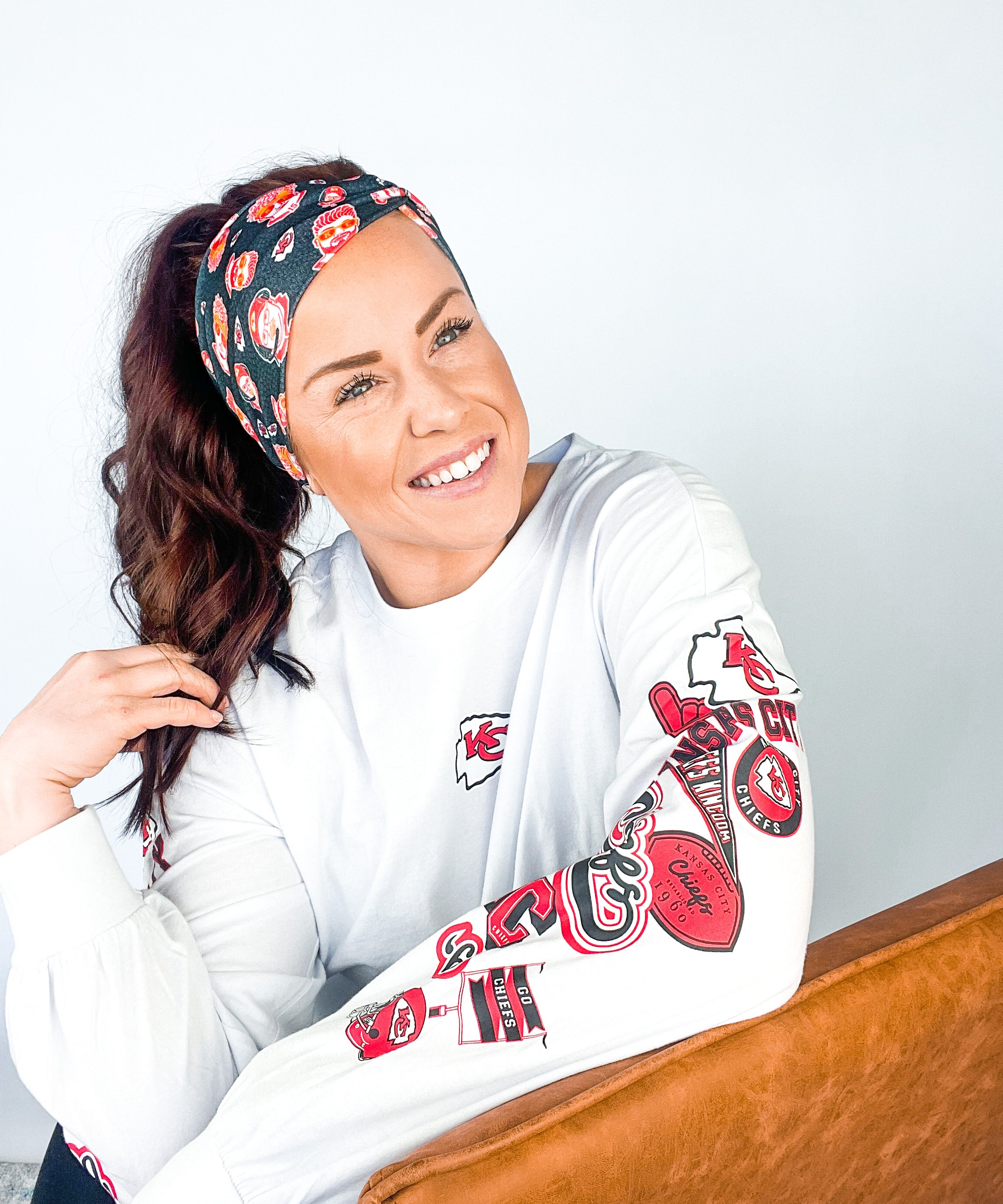 Adult women's black headband with yellow, red and white artistic cartoons of Patrick Mahomes, Avery Reid and Travis Kelce
