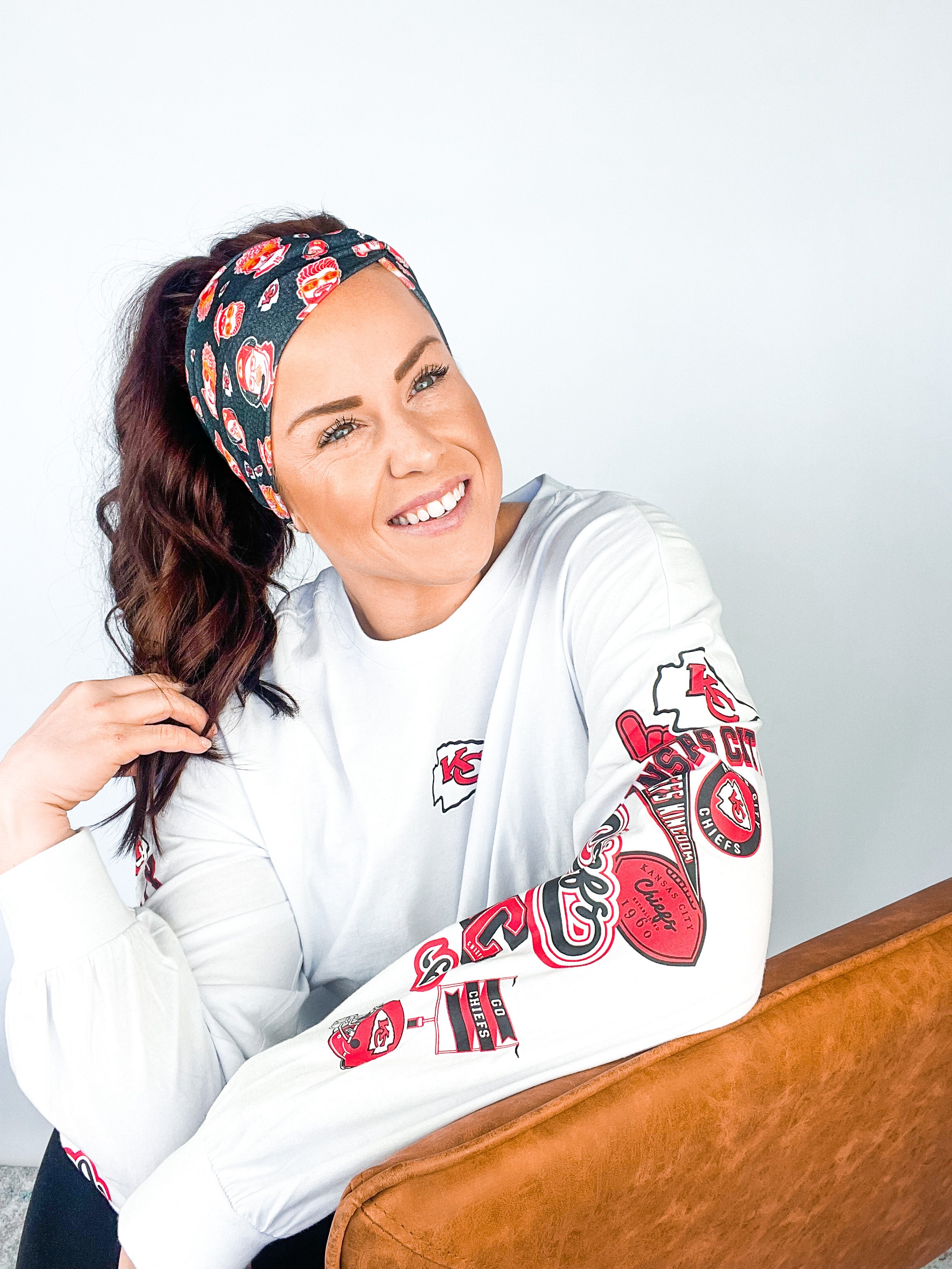 Adult women's black headband with yellow, red and white artistic cartoons of Patrick Mahomes, Avery Reid and Travis Kelce