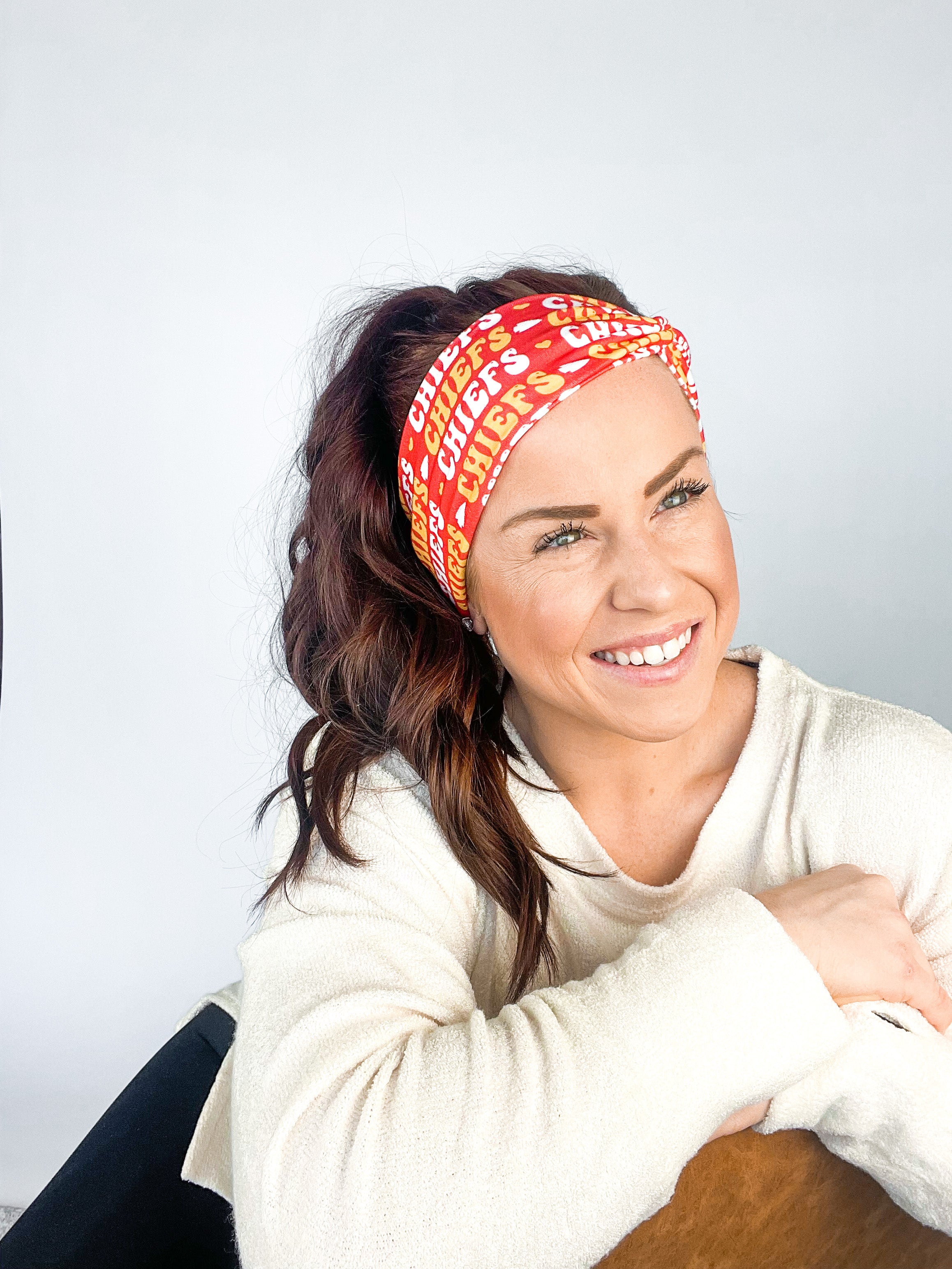 Adult women's red headband with yellow and white 1970's bubble script with the phrase "Chiefs" and an arrowhead