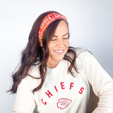 Adult women's red headband with yellow and white 1970's bubble script with the phrase "Chiefs" and an arrowhead
