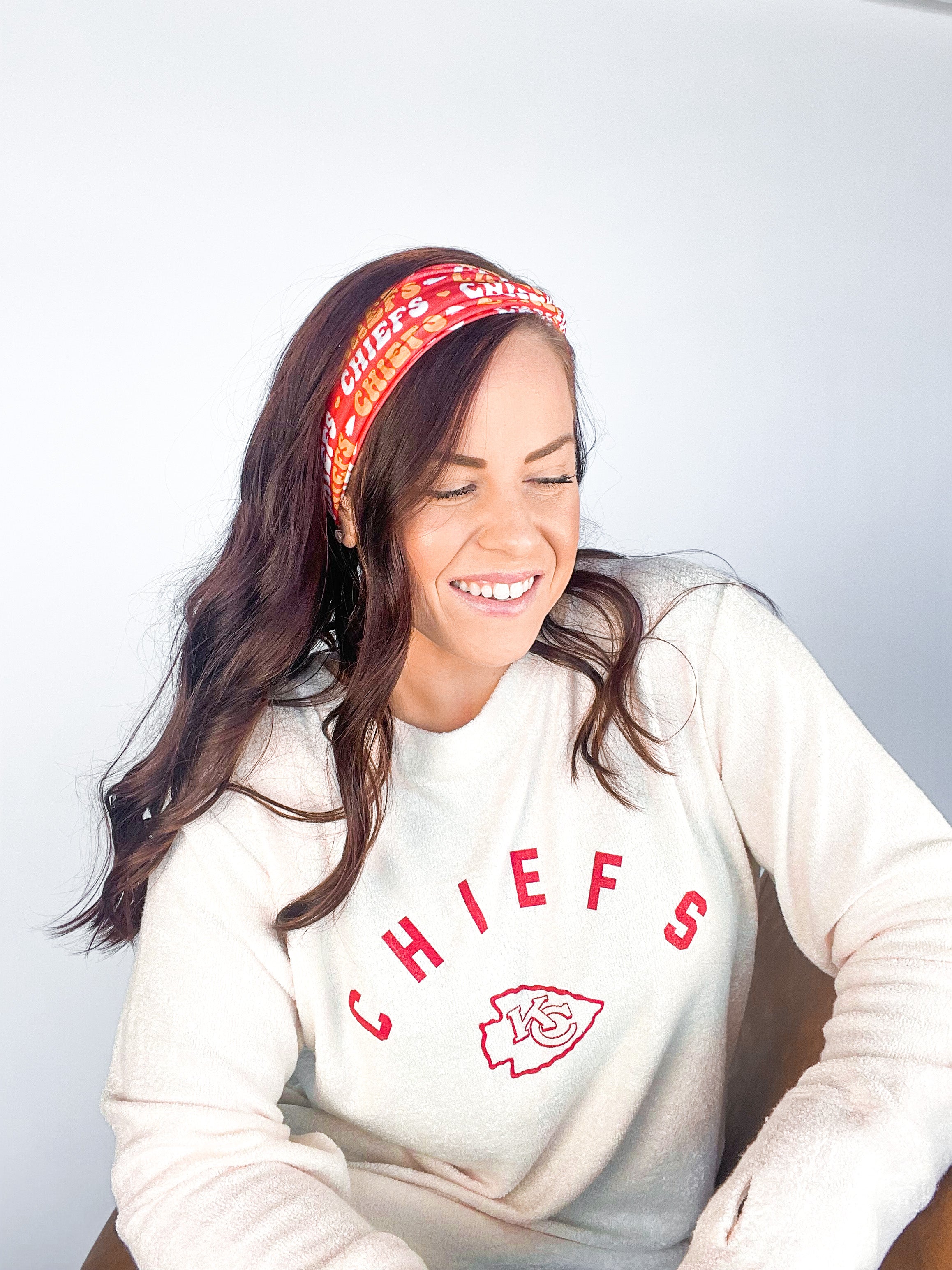 Adult women's red headband with yellow and white 1970's bubble script with the phrase "Chiefs" and an arrowhead