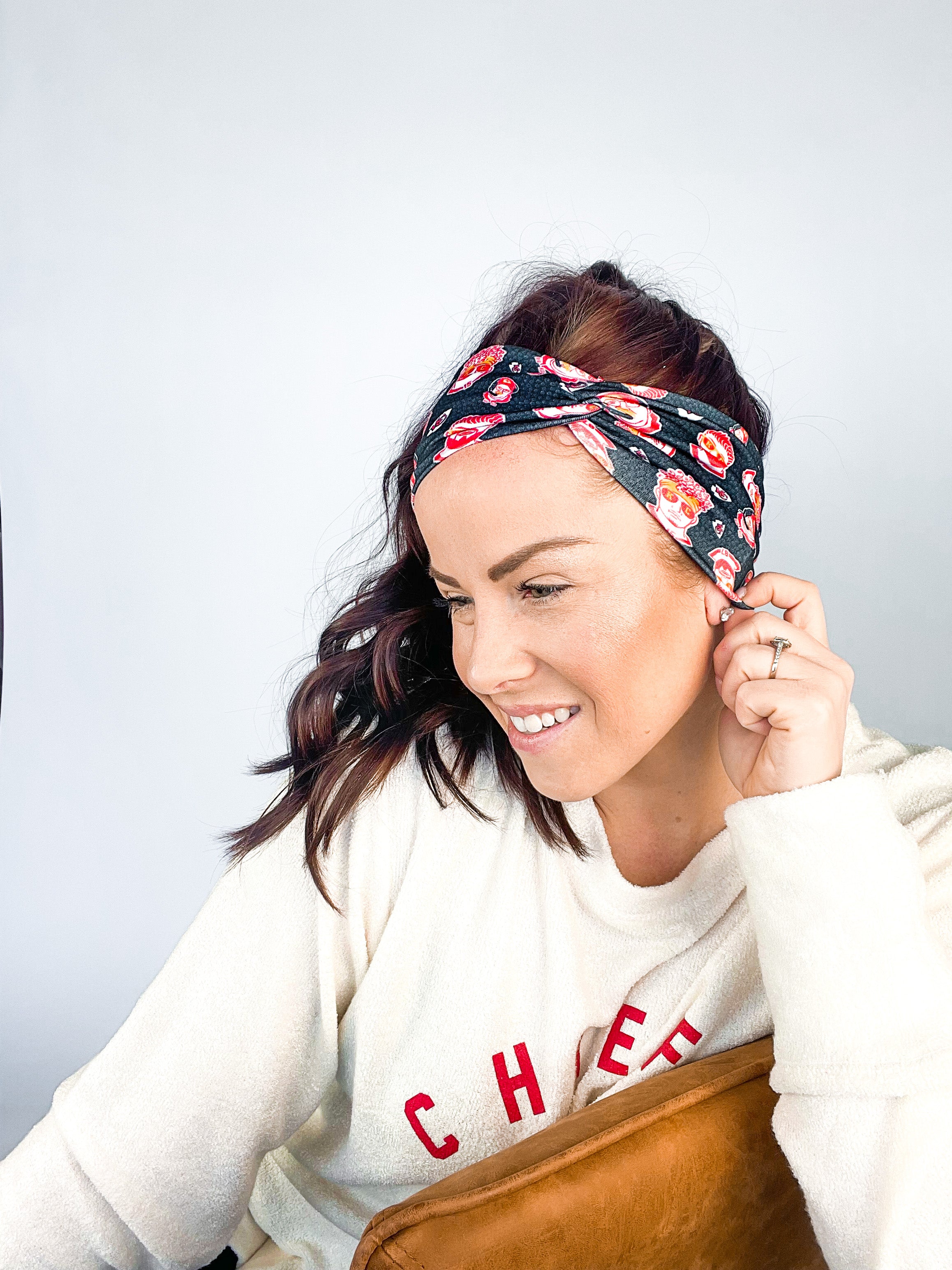 Adult women's black headband with yellow, red and white artistic cartoons of Patrick Mahomes, Avery Reid and Travis Kelce