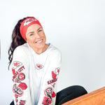 Adult women's red headband with one white arrowhead and red "KC" font in the center