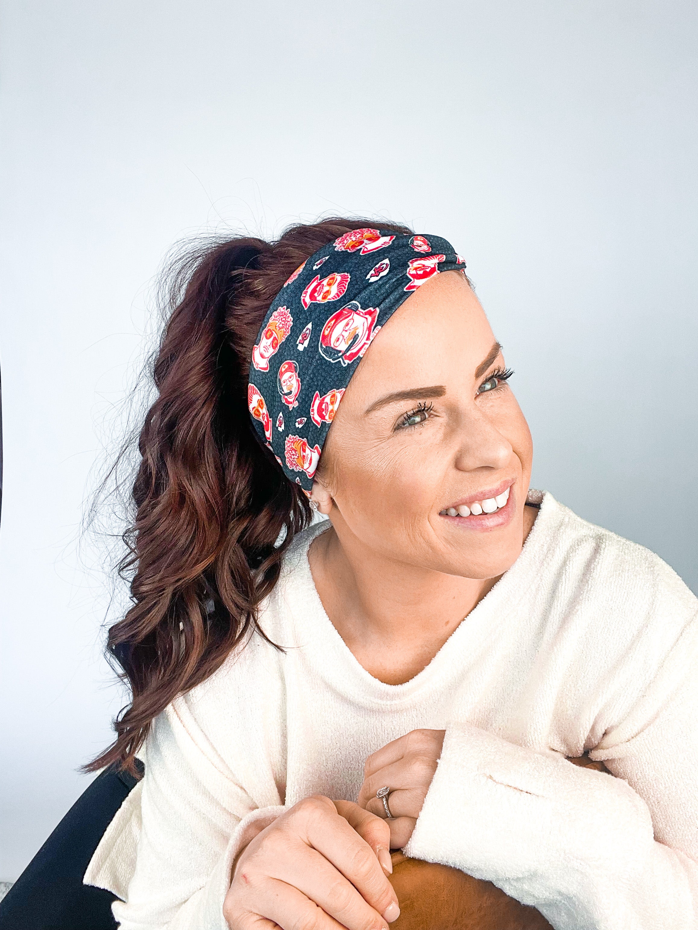 Adult women's black headband with yellow, red and white artistic cartoons of Patrick Mahomes, Avery Reid and Travis Kelce