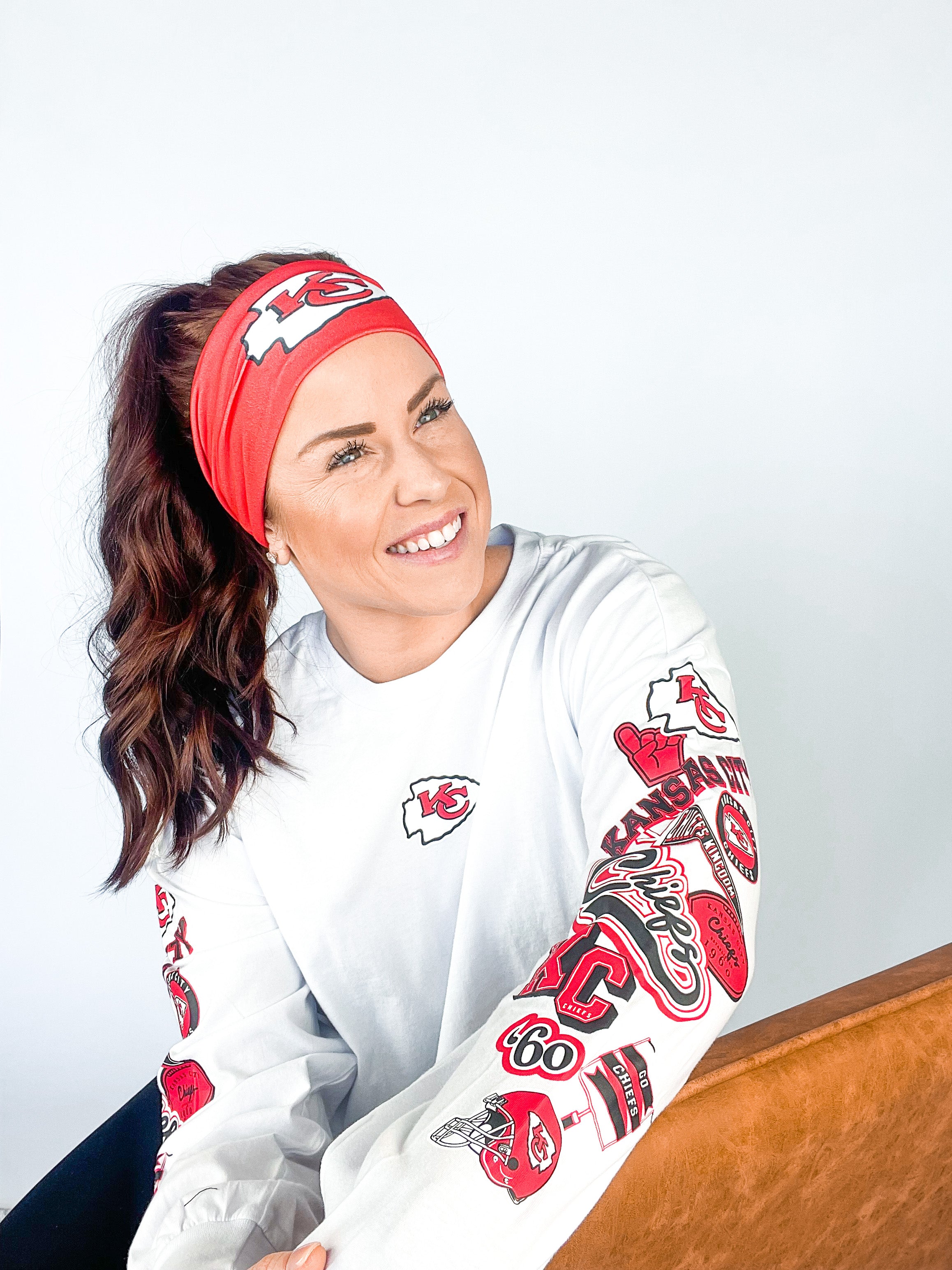 Adult women's red headband with one white arrowhead and red "KC" font in the center