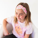 Adult women's peach headband with purple, blue, orange, yellow, green and pink candy hearts with various Valentine's sayings