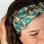 Adult women's dark green headband with yellow corn on the husk with different shades of green leaves