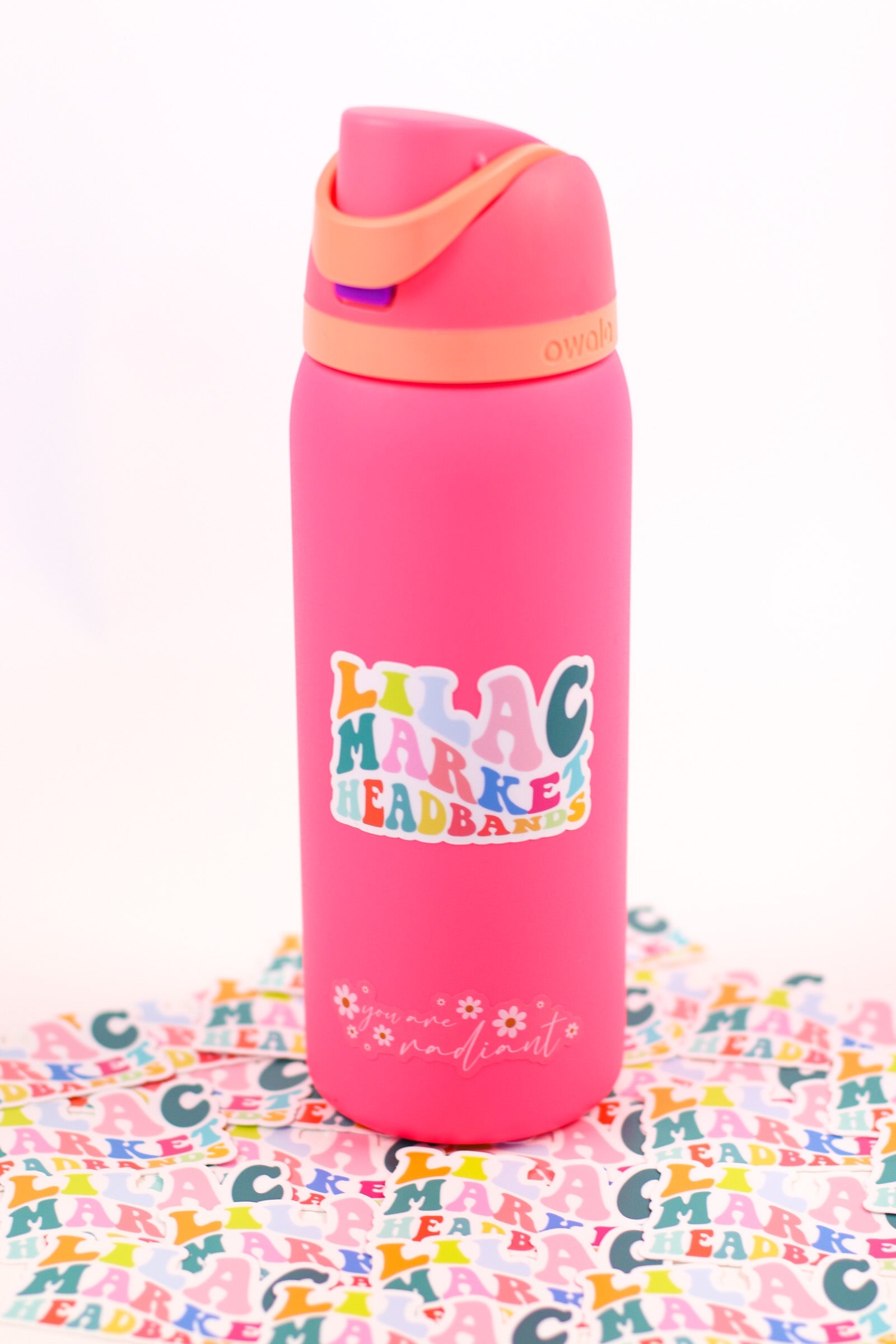 Decorative sticker with 70's style big and small font with the words "Lilac Market" with each letter a different color including orange, pink, teal, green, and blue.