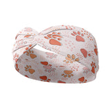 Adult women's ivory headband with blush, tan and orange pawprints and tiny dots