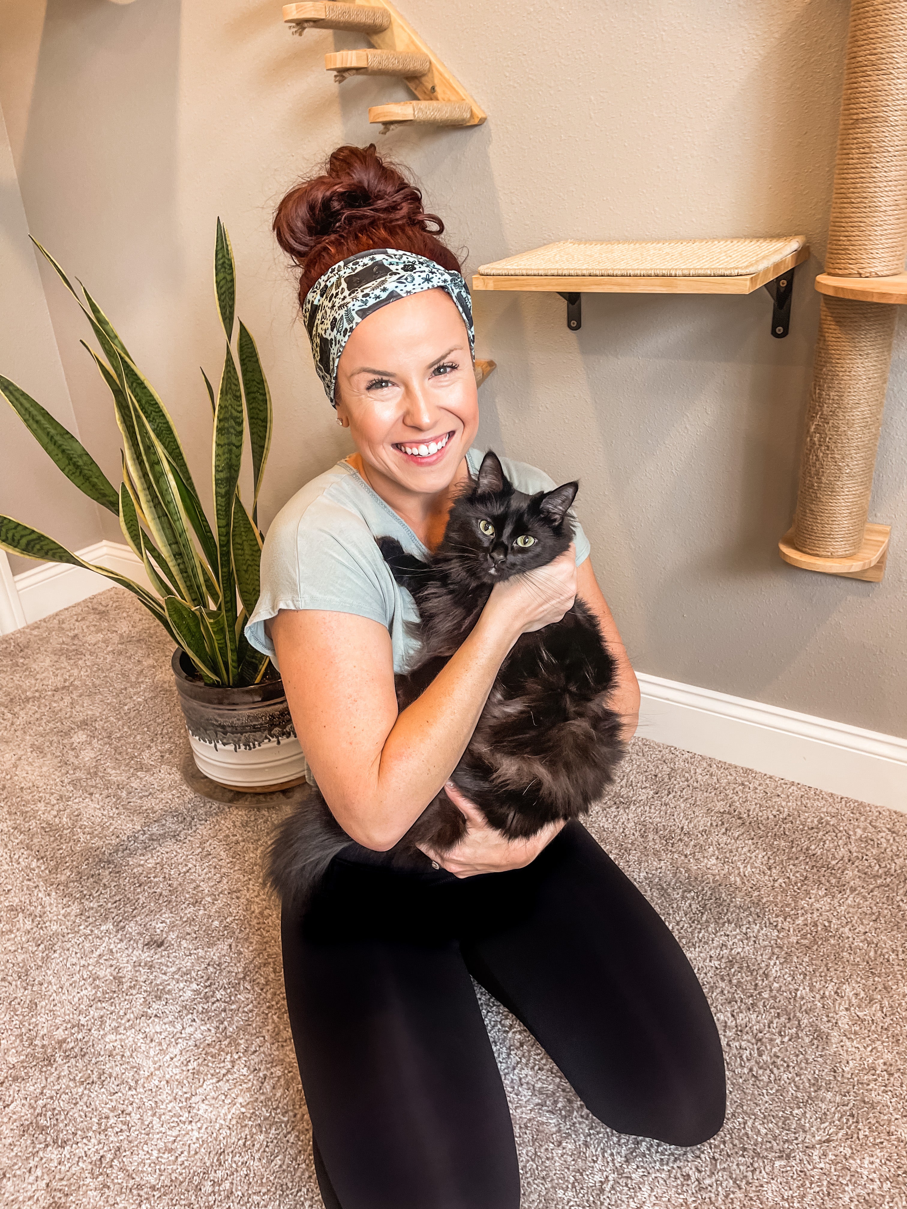 Adult women's sage headband with black cat art peaking over with small black flower and dot outlines