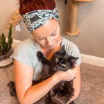 Adult women's sage headband with black cat art peaking over with small black flower and dot outlines