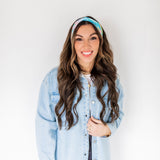 Adult women’s headband with allover layered watercolor paint brushstroke print in varying oranges, pinks, yellows, blues, greens and whites.