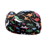 Adult women's black headband with orange, red, blue, grey and pink dinosaur silhouettes with similar colored plants