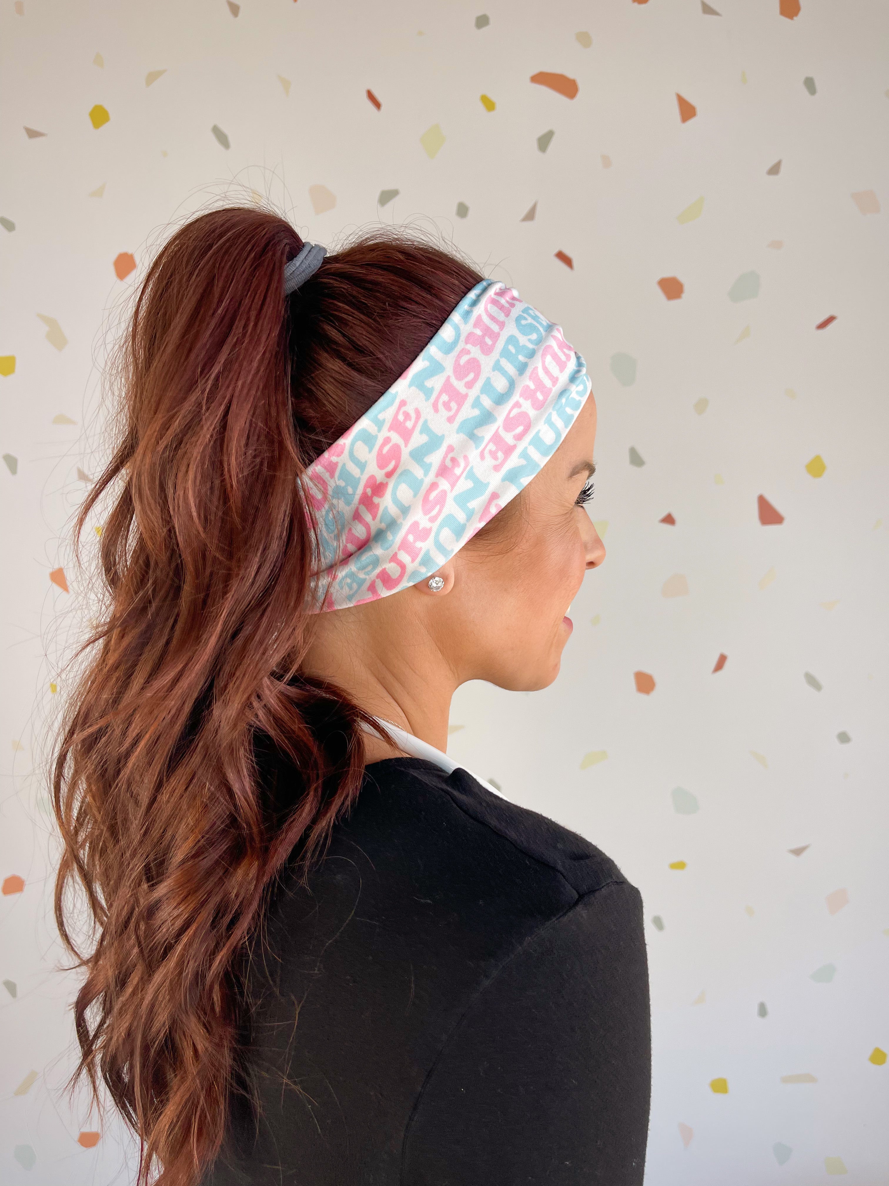 Adult women's white headband with pink and blue allover text saying "nurse"