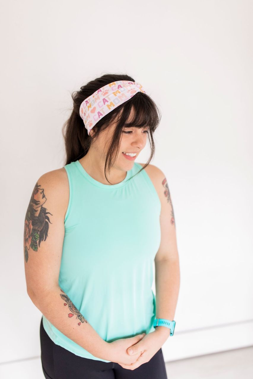 Adult women's white headband with orange, slate, tan, blush and plum pawprints, hearts and words they say "cat mom"